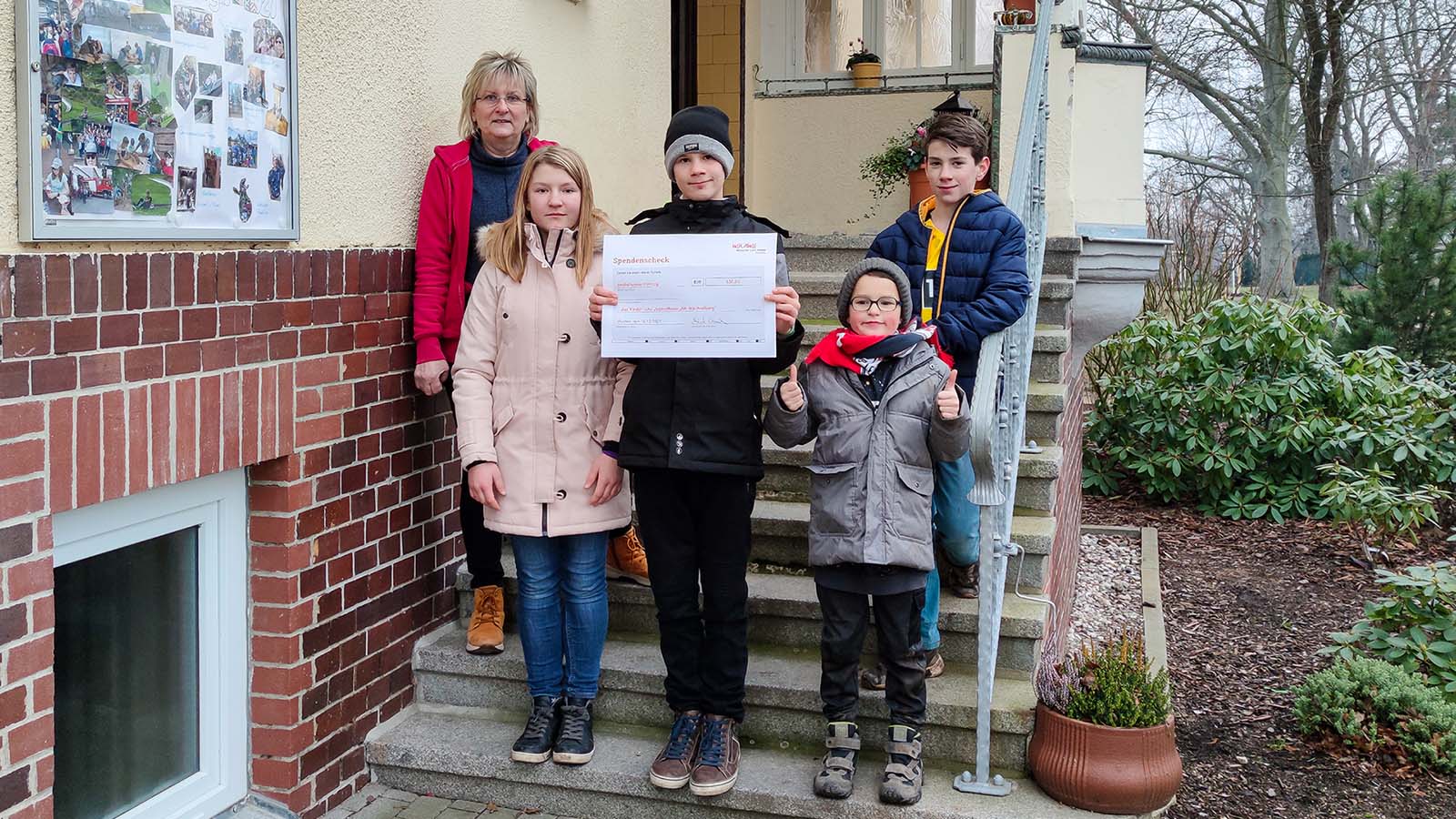 Martina Jüntschke nimmt den Spendenscheck mit den Kindern entgegen