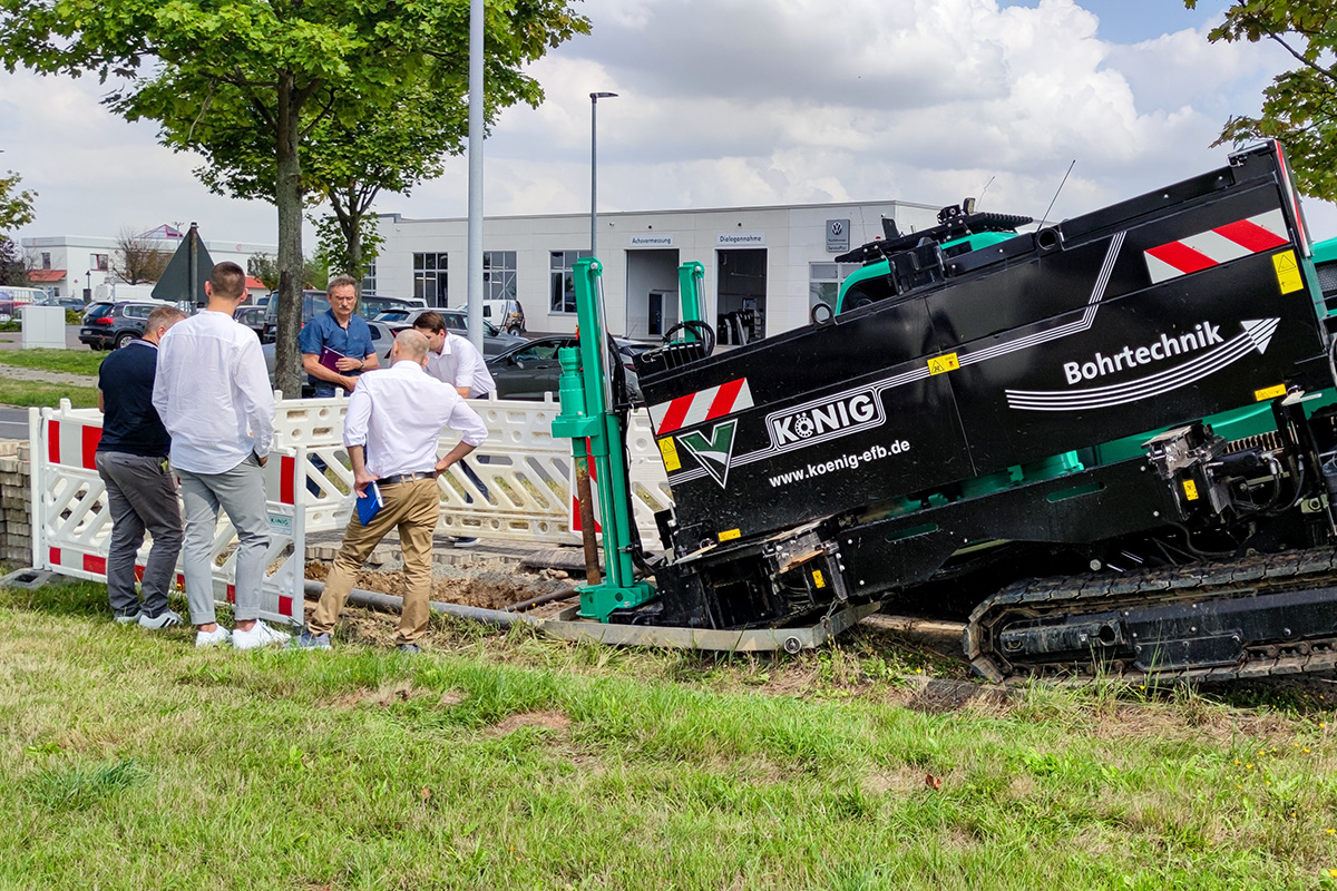 Der Prüfer begutachtet die Grube für das Spülbohrverfahren mit den Projektverantwortlichen der Baufirma