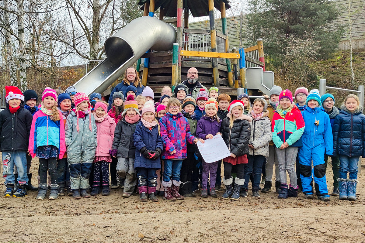 Stefanie Kleine mit den Kindern aus dem Hort Bennewitz und Hortleiter Lars Werner auf dem Spielplatz