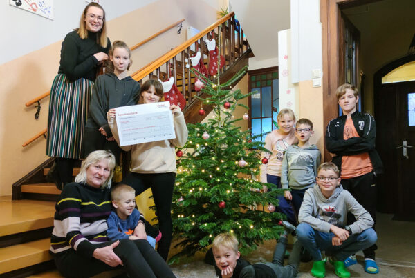 Die Kinder des Kinder- und Jugendhauses „Am Wachtelberg“ mit Einrichtungsleiterin Martina Jüntschke und Geschäftsführerin Stefanie Kleine am Weihnachtsbaum