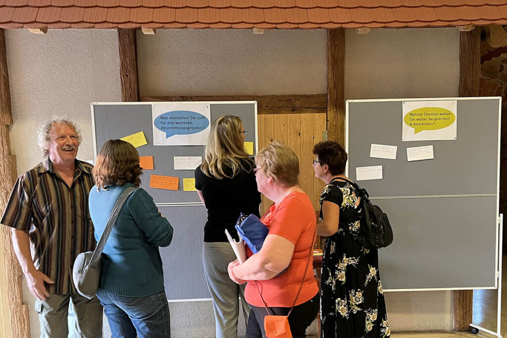 HOLDING - 1. und 2. Bürgerdialog Thallwitz 2 Eine Menschengruppe betrachtet die Fragestellungen an den Aufstellern