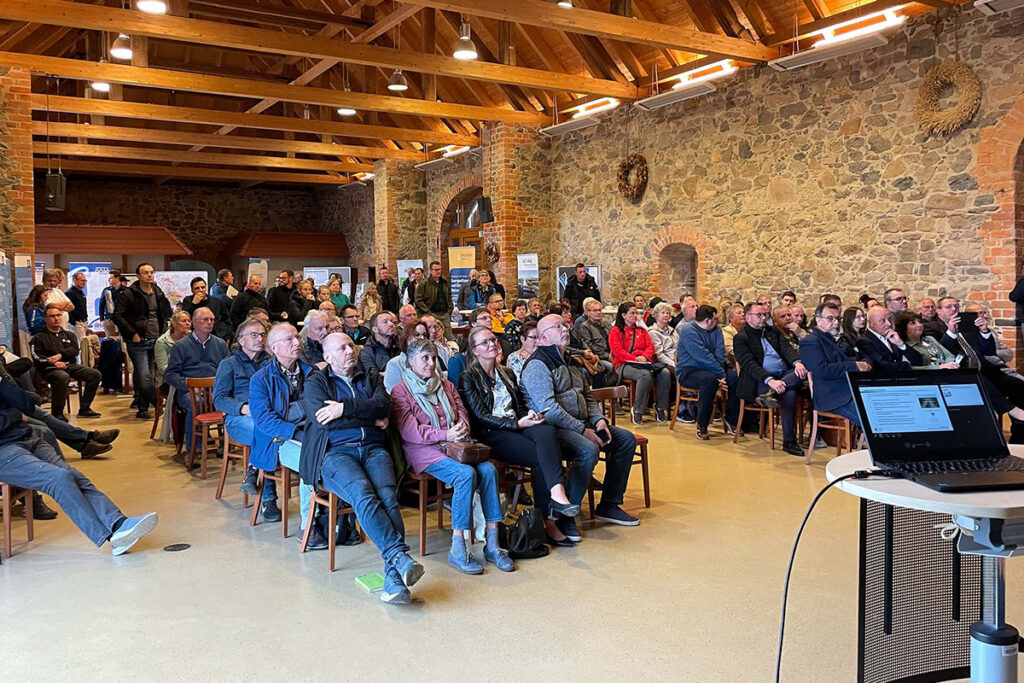 HOLDING - 4. Bürgerdialog Thallwitz 2 Menschen hören sich einen Impulsvortrag im KulturGUT Thallwitz an