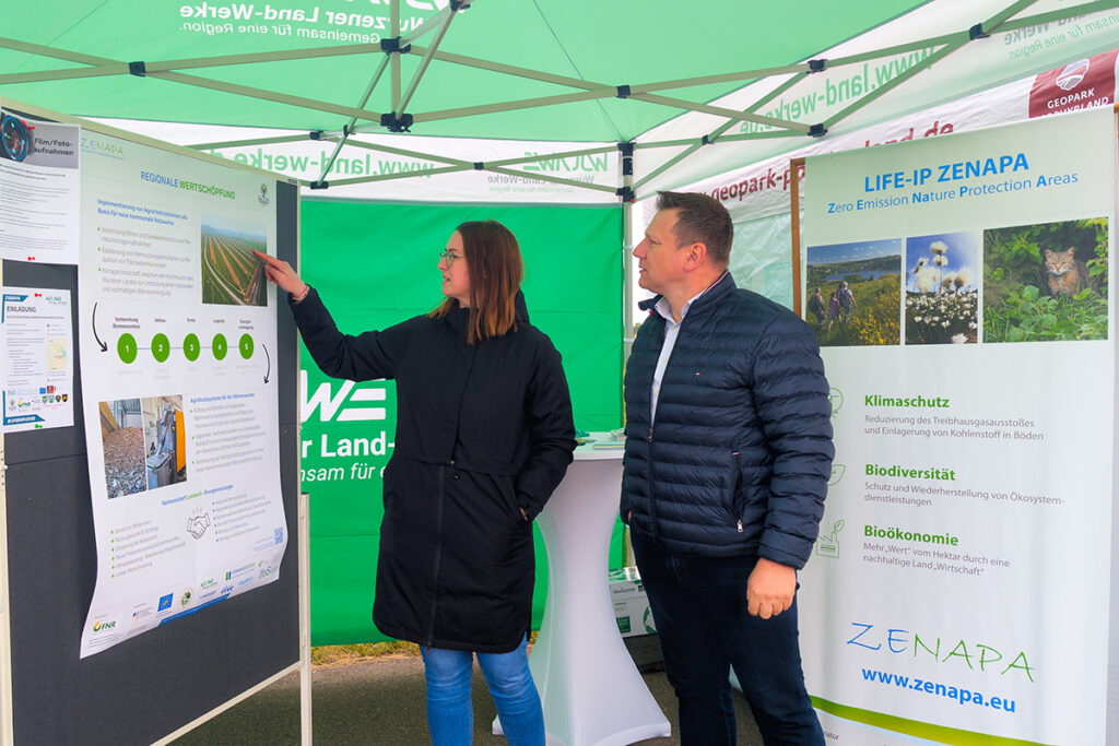 Zelt der Wurzener Land-Werke Stefanie Kleine zeigt die Gehölzstreifen des Agroforstes auf einer Karte im Zelt der Wurzener Land-Werke