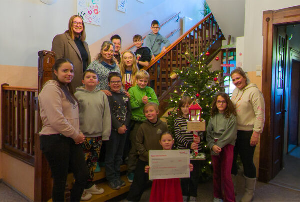 Stefanie Kleine mit Mandy Öhlert und den Kindern und Jugendlichen im Foyer des Kinder- und Jugendhauses "Am Wachtelberg"