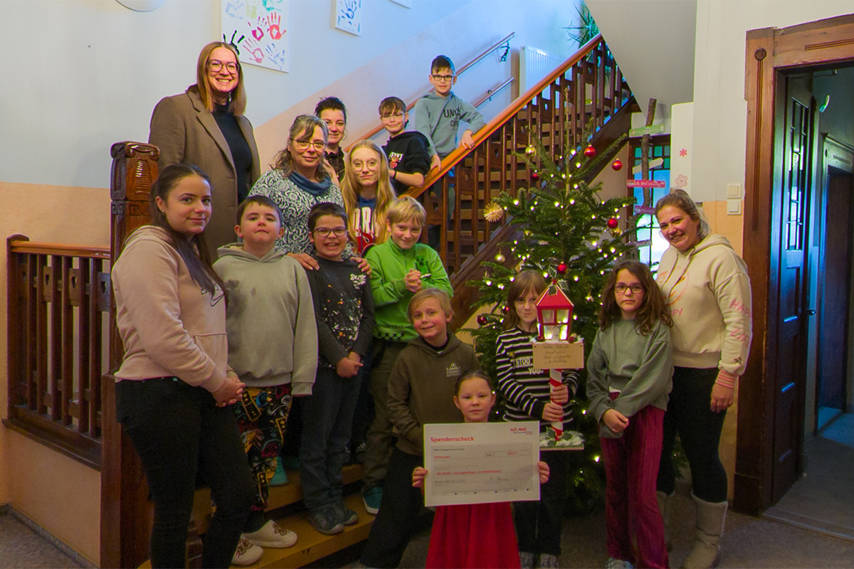 Stefanie Kleine mit Mandy Öhlert und den Kindern und Jugendlichen im Foyer des Kinder- und Jugendhauses "Am Wachtelberg"